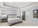 Light-filled main bedroom features a tray ceiling, two windows, and a sliding barn door to the bath at 448 Iverson Way, Charlotte, NC 28203