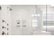 Shower featuring multiple shower heads, recessed shelves, a tiled bench, and a window at 448 Iverson Way, Charlotte, NC 28203