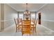 Formal dining room with natural wood table and seating, featuring neutral carpet and chandelier lighting at 6458 Chadwell Ct # 30, Indian Land, SC 29707