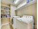 Bright laundry room has shelving above the washer and dryer at 6458 Chadwell Ct # 30, Indian Land, SC 29707