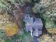 Aerial view of house with wooden deck and stone firepit nestled within a tree-covered lot at 7512 Walkup Rd, Waxhaw, NC 28173