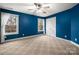Spacious bedroom with blue walls, carpeted floors, and double windows at 7512 Walkup Rd, Waxhaw, NC 28173