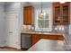 Well-lit kitchen with wooden cabinets, stainless steel dishwasher and a window providing natural light and a view of the outdoors at 7512 Walkup Rd, Waxhaw, NC 28173