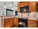 Kitchen features stainless steel appliances, black oven, wood cabinets and a tiled backsplash for the perfect cooking space at 7512 Walkup Rd, Waxhaw, NC 28173