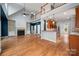 Open-concept living room with fireplace, hardwood floors, and an open kitchen, perfect for entertaining Gathering and friends at 7512 Walkup Rd, Waxhaw, NC 28173