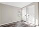 Empty bedroom with wood grain floors, window with blinds, and access to storage at 8670 Carroll St, Hickory, NC 28601