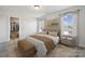 Bedroom with large windows, neutral decor, bedside tables, a bench, and a walk-in closet at 9096 El Sworth Dr, Sherrills Ford, NC 28673