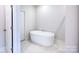 Modern bathroom featuring a standalone tub, marble floors, and door at 9528 Pointer Rd # 63, Huntersville, NC 28078