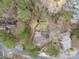 Aerial view of a roof highlighting its unique layout and backyard landscaping nestled within trees at 10031 Bora Bora Dr, Tega Cay, SC 29708