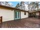 Spacious wooden deck with blue french doors overlooking the serene, wooded backyard at 10031 Bora Bora Dr, Tega Cay, SC 29708