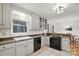 Classic kitchen with white cabinets, neutral countertops, and modern black appliances at 10031 Bora Bora Dr, Tega Cay, SC 29708