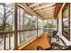 Relaxing covered porch with classic white columns, wood floors, and comfortable seating area at 10031 Bora Bora Dr, Tega Cay, SC 29708