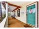 Charming covered porch featuring classic white railings, wood floors, and an inviting teal door at 10031 Bora Bora Dr, Tega Cay, SC 29708