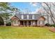Charming brick home featuring a lush green lawn, covered front porch, and classic architectural details at 1017 Patrick Johnston Ln, Davidson, NC 28036