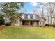 Charming front exterior of the brick home with a well manicured lawn and mature trees at 1017 Patrick Johnston Ln, Davidson, NC 28036