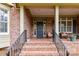 Welcoming front porch with brick flooring, comfortable seating, and a view of the manicured front yard at 1017 Patrick Johnston Ln, Davidson, NC 28036