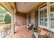 Cozy front porch featuring brick details, comfortable seating, and space for decorative plants at 1017 Patrick Johnston Ln, Davidson, NC 28036