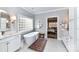Bright main bathroom featuring a soaking tub, white cabinets, and modern fixtures at 1017 Patrick Johnston Ln, Davidson, NC 28036