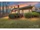 Rear exterior view of the brick home with a wooden deck, mature landscaping, and a view of the sky at 1017 Patrick Johnston Ln, Davidson, NC 28036