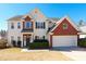 Charming two-story home features a brick and siding facade, attached two-car garage, and manicured front yard at 1066 Streamlet Way, Monroe, NC 28110