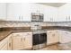 Modern kitchen with white cabinets, stainless steel appliances, and decorative backsplash at 1066 Streamlet Way, Monroe, NC 28110