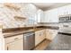 Stylish kitchen featuring stainless steel appliances, unique backsplash, and floating shelves at 1066 Streamlet Way, Monroe, NC 28110