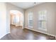 Inviting living room bathed in natural light, showcasing new hardwood floors and an open layout, with a glimpse of the dining room at 1066 Streamlet Way, Monroe, NC 28110