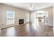 Open concept living room featuring a fireplace, ceiling fan, hardwood floors, and an archway leading to the kitchen at 1066 Streamlet Way, Monroe, NC 28110