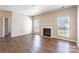 Bright living room featuring a fireplace, neutral walls, and wood-look flooring at 1066 Streamlet Way, Monroe, NC 28110