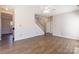 Spacious living room with hardwood floors, staircase, ceiling fan, archway to kitchen, and natural light at 1066 Streamlet Way, Monroe, NC 28110