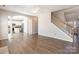 Spacious living room with hardwood floors, staircase, ceiling fan, archway to kitchen, and natural light at 1066 Streamlet Way, Monroe, NC 28110