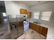 Eat-in kitchen featuring tile floors, wooden cabinets, ample counter space, and stainless steel refrigerator at 110 2Nd St, Spencer, NC 28159