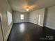 A spacious living room with dark wood floors, a ceiling fan, and natural light streaming through the windows at 110 2Nd St, Spencer, NC 28159