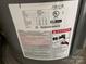 Close up view of a Rheem electric water heater showing the serial number, model, wattage, and safety warnings at 110 2Nd St, Spencer, NC 28159