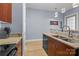 Bright kitchen featuring stainless steel sink, granite countertops, and wooden cabinets at 1101 W 1St St # 124, Charlotte, NC 28202