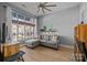 Living room featuring a gray sectional sofa, a ceiling fan, and a large window with natural light at 1101 W 1St St # 124, Charlotte, NC 28202