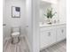 Bright bathroom featuring dual sinks, white cabinetry, modern fixtures, and wood-look flooring at 11205 Cardinal Creek Ave, Charlotte, NC 28215