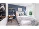 Cozy bedroom with a large window, desk, and bed accented with blue wall and comfortable bedding at 11205 Cardinal Creek Ave, Charlotte, NC 28215