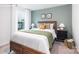 Comfortable bedroom with a large window, and a wooden bed frame with green and beige accent pillows at 11205 Cardinal Creek Ave, Charlotte, NC 28215