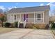 Charming home featuring a covered porch, a purple front door, and nicely maintained landscaping at 114 Glen Rae Sw St, Concord, NC 28025