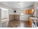 Kitchen with hardwood floors and a brick accent wall, featuring wood cabinets and ample counter space at 114 Glen Rae Sw St, Concord, NC 28025