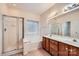 Bright bathroom featuring a shower, soaking tub, and double vanity with wood cabinets and a large mirror at 127 Lakewood Circle Dr, Mooresville, NC 28117