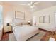 Staged bedroom with a ceiling fan, two windows, modern lamps, and hardwood floors at 127 Lakewood Circle Dr, Mooresville, NC 28117