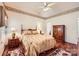 Bedroom with a ceiling fan, floral wallpaper, two lamps, armoire, and hardwood floors at 127 Lakewood Circle Dr, Mooresville, NC 28117