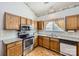 Kitchen with wood cabinets, stainless steel appliances, granite countertops, tile backsplash, and a double sink at 127 Lakewood Circle Dr, Mooresville, NC 28117