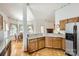 Spacious kitchen with granite countertops, wood cabinets, stainless steel refrigerator, and hardwood floors at 127 Lakewood Circle Dr, Mooresville, NC 28117