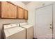Laundry room featuring a white washer and dryer set and wood cabinets above at 127 Lakewood Circle Dr, Mooresville, NC 28117