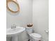 Small bathroom featuring pedestal sink, toilet, and decorated mirror at 13044 Cottage Crest Ln, Charlotte, NC 28273