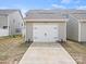 A detached two-car garage with white doors and a concrete driveway in a suburban setting at 13044 Cottage Crest Ln, Charlotte, NC 28273