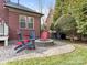 Cozy backyard patio with stone fire pit and colorful Adirondack chairs, perfect for outdoor relaxation at 13114 Long Common Pkwy, Huntersville, NC 28078